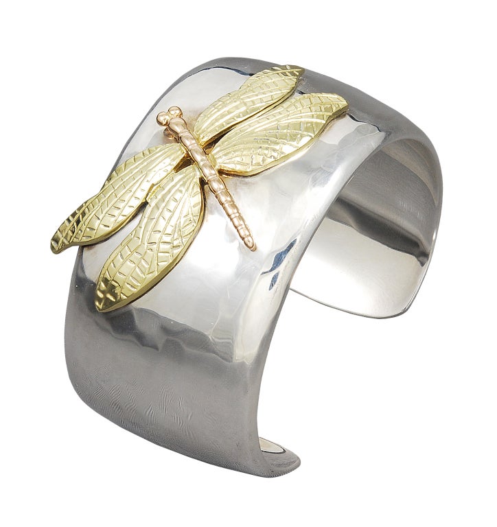 Wide hand-hammered sterling silver cuff bracelet with 18K gold figural applied dragonfly, signed Tiffany & Co.This bracelet was brought back by Tiffany in 2001 and now is no longer available. A Classic!!!