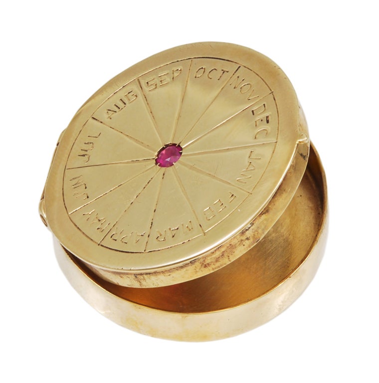 14K gold hinged pill box with faceted ruby center showing months of the year.Perfect and elegant for your pills