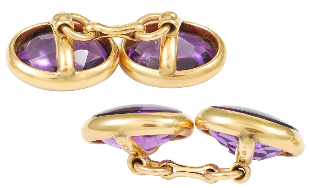 Antique oval double-sided cufflink in 14K yellow gold.  Each side is set with a bright amethyst, which is faceted on the bottom and cabochon on top.  A beautiful cufflink.