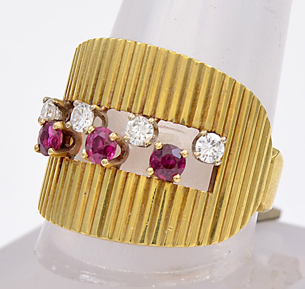 Unique wide fluted 18k gold ring that hugs the finger signed Dunay.Alternateing diamond and rubies across the center makes for an most elegant look.Very stylish and striking. Size 7 1/4 and may be sized.