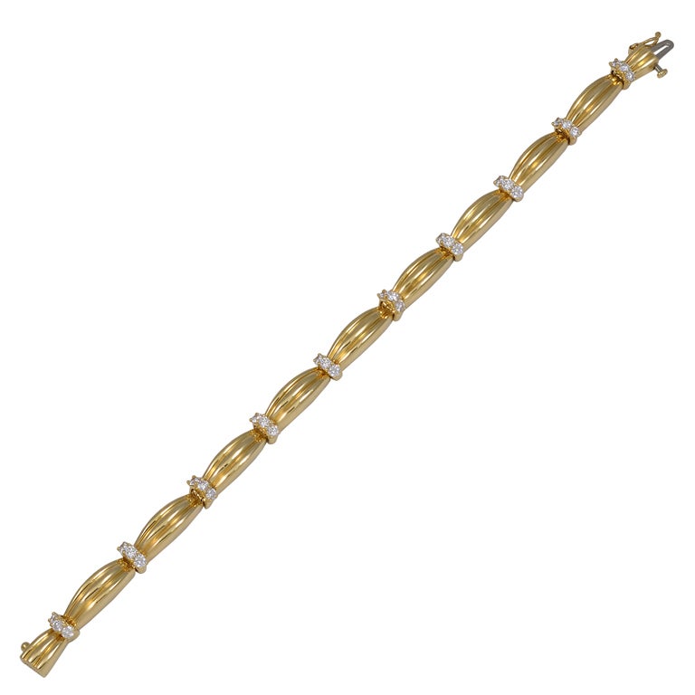 TIFFANY & CO 18K diamond link bracelet. Very attractive and wearable. Ribbed links interspersed with bars consiting of 3 brilliant cut diamonds. Total weight 1 .50cts.
Looks beautiful on its own or in tandem with another bracelet or watch. Silky