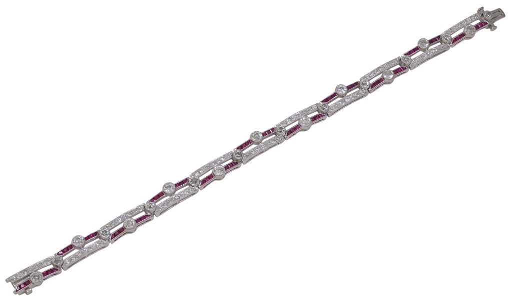 This is a fabulous Diamond and Ruby art deco bracelet. This is a true period piece.
3.50cts. of brilliant sparkling diamonds. 1.75cts of vibrant vivid colored rubies. Set in platinum. Alternating rows of diamonds and rubies set with round bezel set