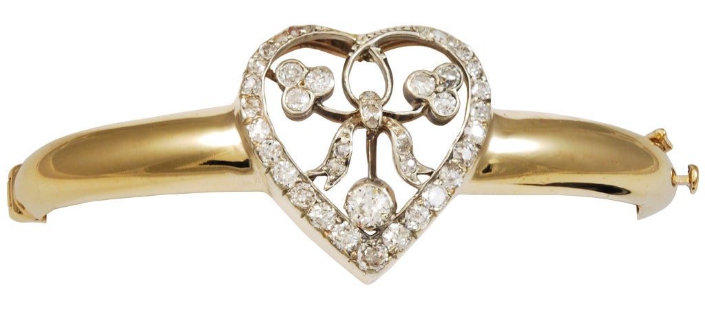 Unique 14k gold bangle bracelet with applied heart cartouche. The heart is delicately cut out and is fully set with shimmering old European cut diamonds. This is a lovely, charming one-of-a-kind bracelet.