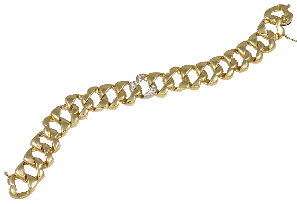 TIFFANY & CO 18k gold link bracelet. Each link is a figural heart; the center heart is all over set with fine diamonds.Unusal and orignal design, can be worn alone or would layer beautifully with other bracelets. A lovely slinky texture.