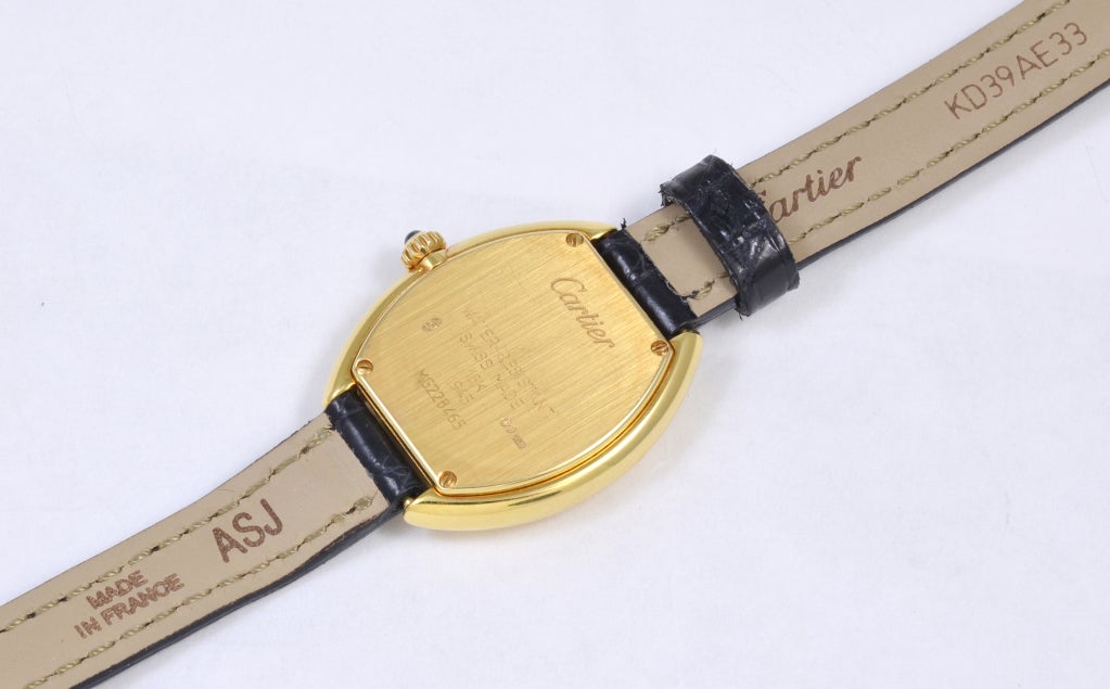 Lady's 18k yellow gold Cartier tonneau wristwatch. Swiss quartz movement. Black Caiman shiny strap. An elegant, timeless look.
