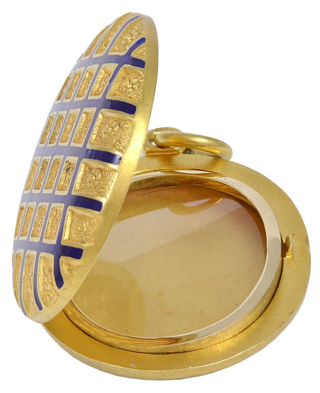 Large oval antique locket set in 15 carat yellow gold. Cobalt blue enamel diamond -shape pattern, set with exquisite finely detailed raised gold florets. Opens to reveal dual bezels that hold two pictures.
2 inches long x 1 1/3