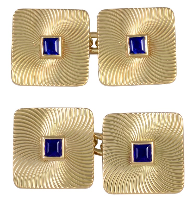 Outstanding 18K gold double-sided cufflinks, signed Bulgari. Square cut sapphire set in center of large square cufflink. Beautifully engraved swirl pattern. Polished and handsome. A must see