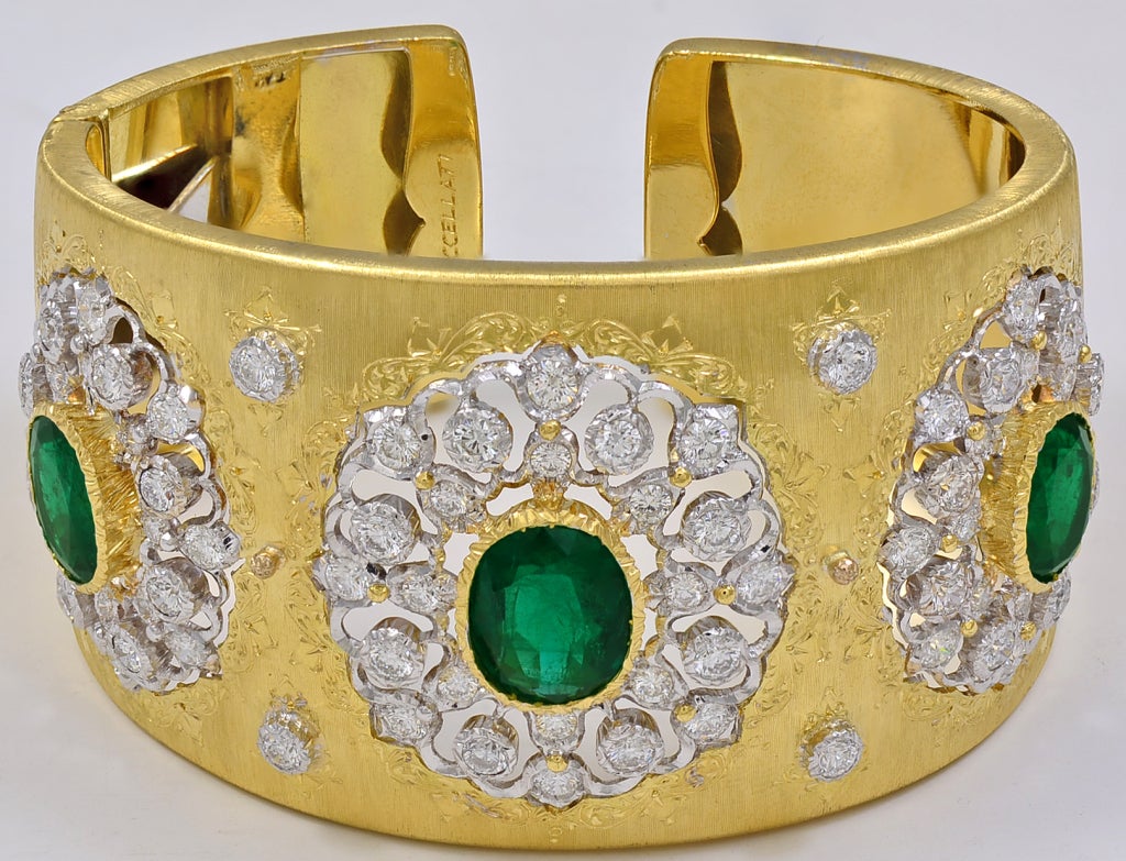 Spectacular 18K gold emerald and diamond cuff made and signed by M. Buccellati. Three gemset sections, each with a large faceted center emerald surrounded by brillant diamonds. The emeralds have a deep rich natural green color. The diamonds are