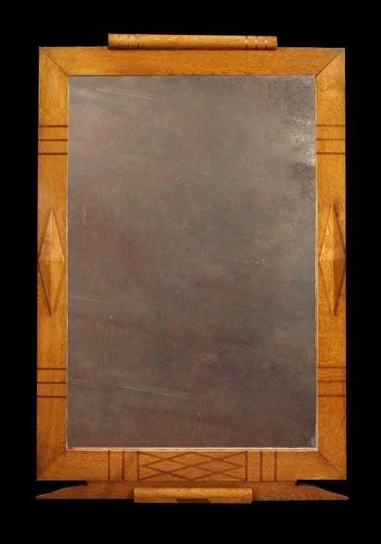 # M077 large Art Deco mirror executed in oak and enriched with inlaid geometric lines and diamond patterned raised panels. The beveled rectangular plate surrounded by a richly grained and golden patinated flat oak frame. The simple decorative