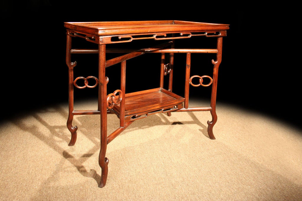 # Q506 - Exotic Chinese Huanghuali rectangular tray-topped two-tier occasional table made for export.  Note the decorative frieze of pierced lozenge shaped stylized forms. All supported on an 