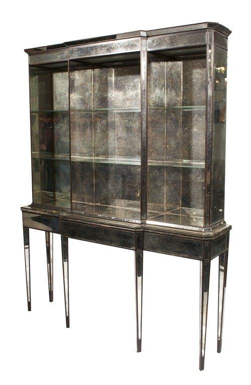 Rare and exceptional mirrored breakfront by Syrie Maugham. Glass shelves in a mirrored, illuminated case atop a mirrored, six leg console. Mercury glass mirror shows beautiful age and patina. Descended through original owners – the Grace and Phipps