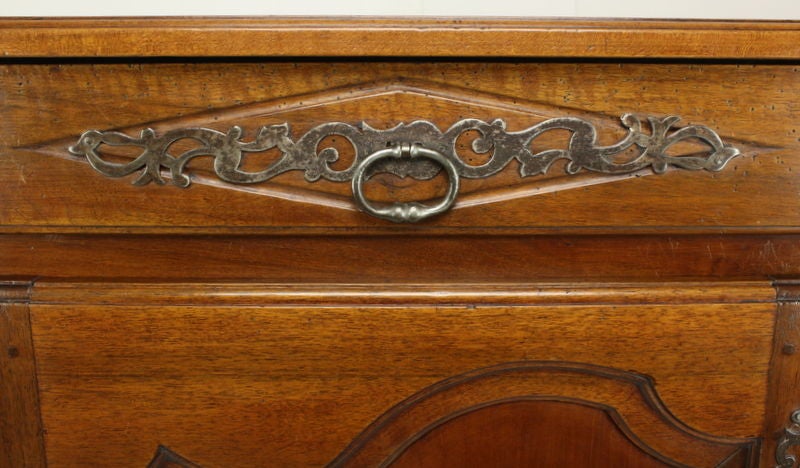 A large sized, beautifully carved, example of a fine French buffet.  The color is very classic, rich and warm.  The original hardware is exuberant and well scaled for the piece.  Two drawers and one long shelf inside provide considerable storage.