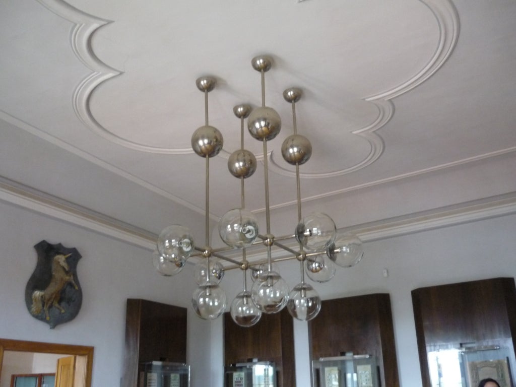 A large nickel chandelier with multiple nickel and glass globes.

German, Circa 1960's

Special Order.