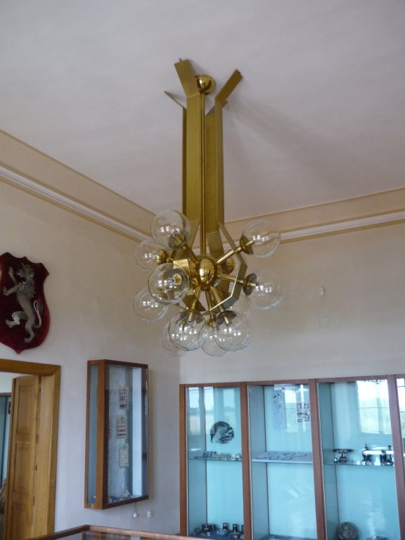 A large brass chandelier with multiple glass globes.

German, Circa 1960's