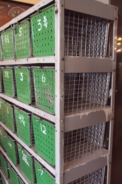 Mid-century swim basket/gym locker system with original green paint and numbers. Excellent vintage condition. 28 galvanized steel wire baskets with loop handle pulls easily slide in and out of steel shelving unit. Multi-purpose storage for