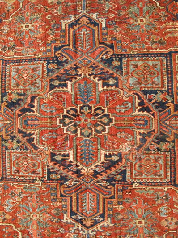 This beautiful Heriz which dates from the early part of the twentieth century is a stunning example of Persian design and craftsmanship. A large multifaceted medallion of Midnight Blue, Various Reds, Blues and Bone rests upon a field in various