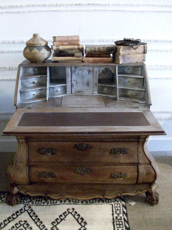 This wonderful secretary was discovered in the Netherlands, but its origin is unknown. It appears to be oak, with a lovely natural waxed finish. The apron is carved and terminates in claw and ball feet. A classic beauty.