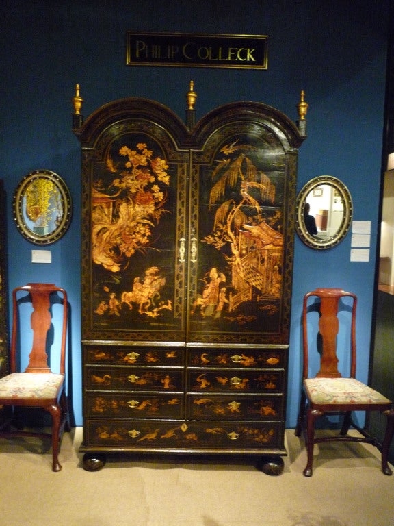 Rare Queen Anne japanned wardrobe cabinet with original chinoiserie decoration, having two long cabinet doors with lower false drawer fronts and a single long drawer below. The arched cabinet doors enclose two shelves and an arrangement of nine
