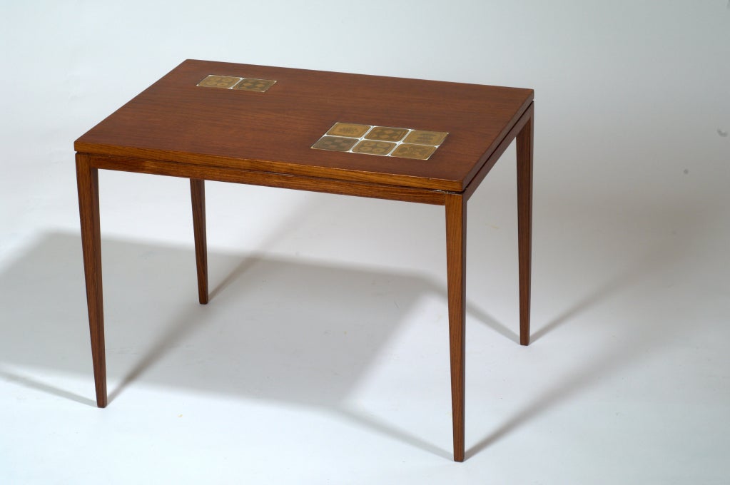 Bjorn Wiinblad für Rosenthal, 1960er Jahre
Ein schöner Tisch  mit eingelegten vergoldeten Porzellanfliesen von Bjorn Wiinblad. Auf der Unterseite befindet sich die Porzellanmarke von Rosenthal.
Maße: 24 x 16 x 18 H.
 