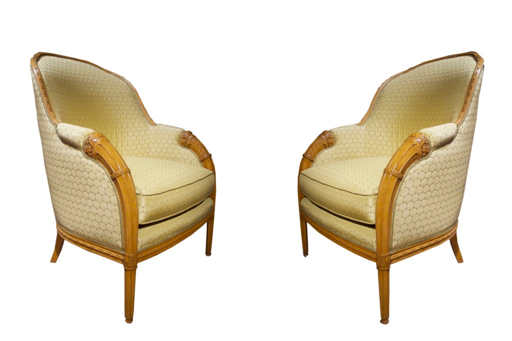# W119, superb pair of Art Deco armchairs in the manner of Paul Follot. The comfortable proportions and stylish design is neatly executed in fruitwood. Note the low relief stylized floral carving on the curved crest rails which sweep into the arm