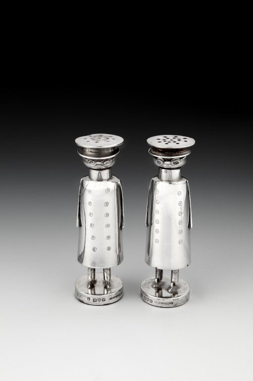 A stylish pair of Sterling silver salt and pepper pots in the form of Edwardian motorists, in stylised motoring attire, with detachable heads for filling, and weighted circular bases, the design affectionately known as the Mr. Popple, each pot