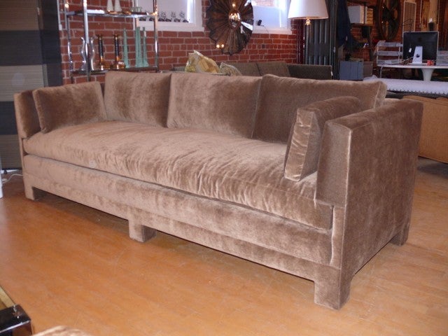 Sumptuous sofa in the manner of Billy Baldwin.  Completely upholstered frame with notched arms , 3 loose back pillows and 2 side pillows all rest on a single down and feather seat.  Covered in a taupe cotton velvet.