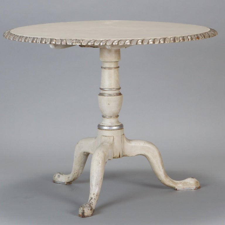 Late 19th century creamy white painted French tilt top table has cabriole tripod base, turned and silver gilt column and round top with fluted, silver gilt  edge.