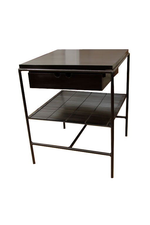 Paul McCobb Planner Group iron framed nightstands with bamboo matting lower shelf surface and single solid maple drawer box. Restored in a hand rubbed black lacquer finish the tables are solid and all parts in fine restored condition.