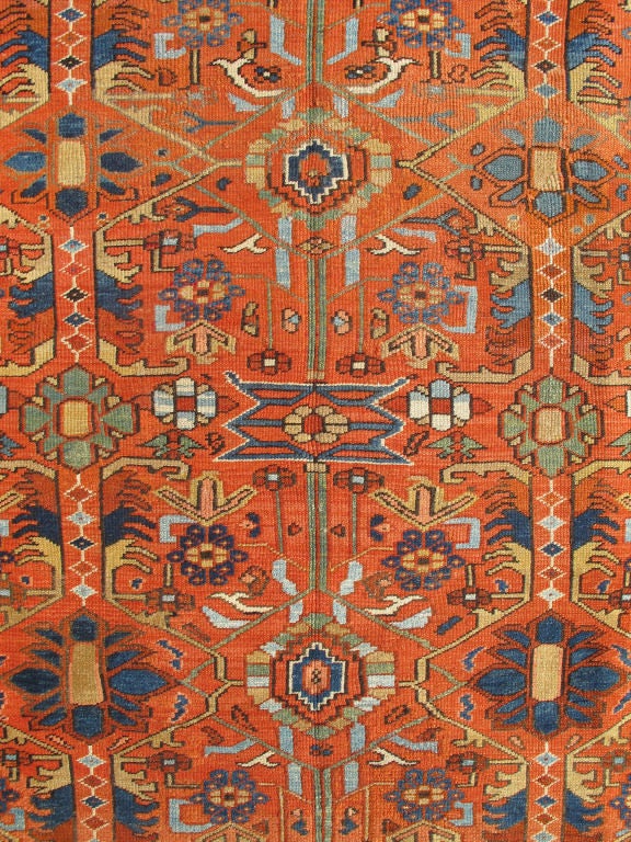 This antique Heriz-Serapi rug is highly unusual due to its all-encompassing geometric design. Linear patterns weave themselves throughout the center field of soft rust and are accompanied by beautifully executed geometric designs. Various shades of