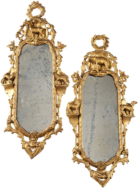 A pair of fourth quarter of the 18th century Italian transitional Rococo to neoclassical Empire giltwood mirrors, both retaining their original mercury glass plates, crested with victory wreaths and embellished with elaborate floral and fruited