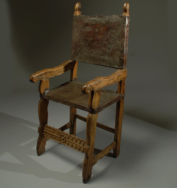 A good 18th century Spanish colonial friar's arm-chair with hand tooled and embossed leather seat and back. Sabino wood with carved stretcher base, sturdy mortise and tenon joinery and deep surface patina throughout.

Dimensions: 47 inches high x