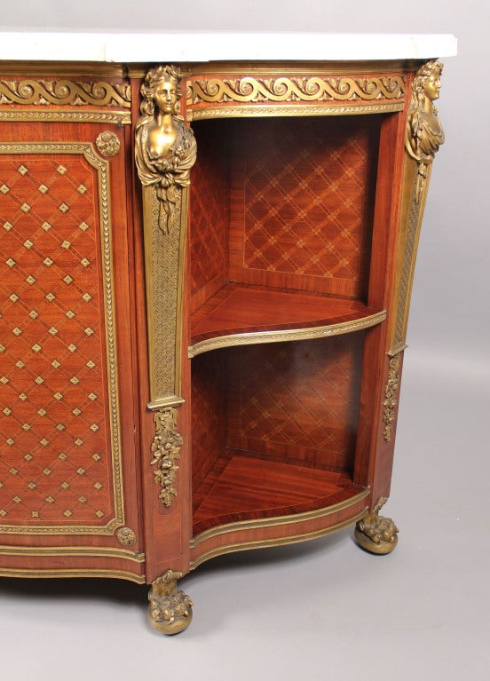 A rare and impressive mid-19th century transitional style gilt bronze-mounted cabinet.

By Charles-Guillaume Winckelsen (1812-1871.)

The demilune white marble-top above a central frieze drawer centered, over a pair of bronze-mounted parquetry