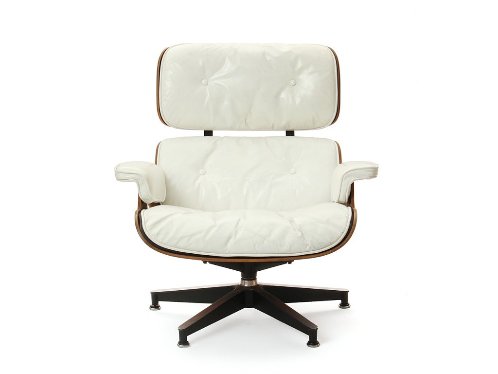 A vintage swiveling lounge chair with ottoman having a highly figured rosewood shell, retaining its original tufted white leather upholstery.