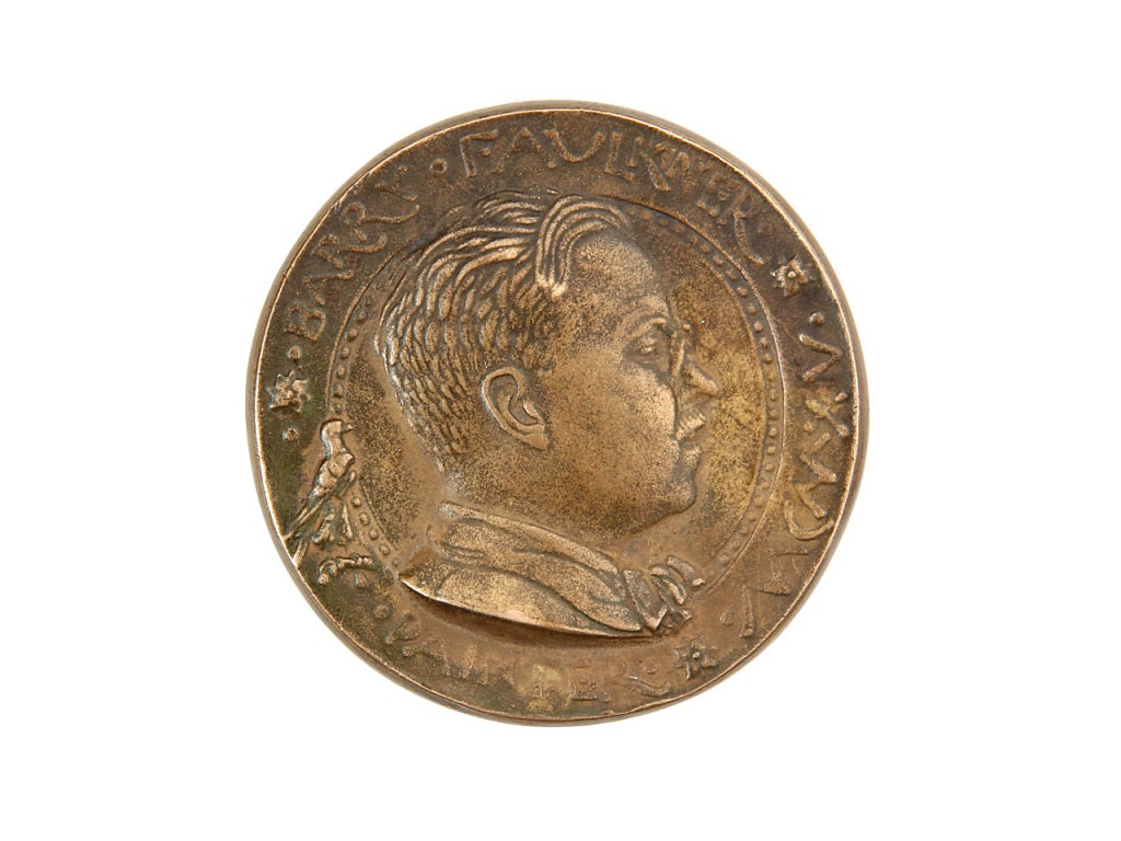 Bronze medallion featuring a portrait and marked 