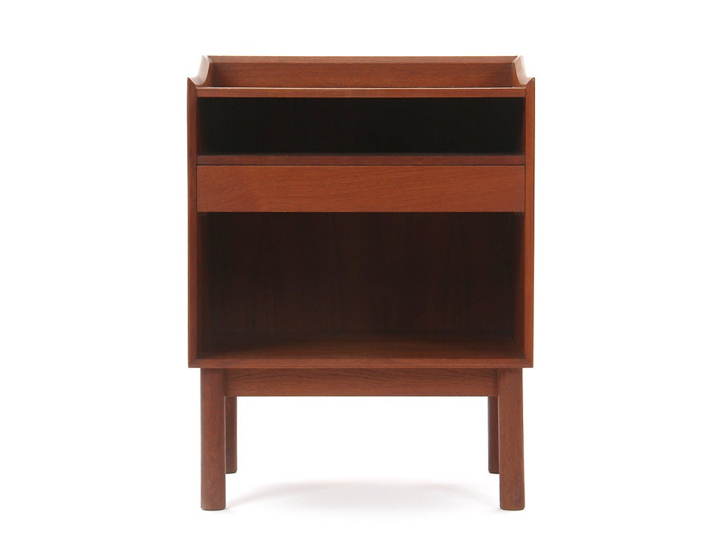 A pair of solid teak nightstands with a single drawer and finger-jointed cases, on dowel legs.