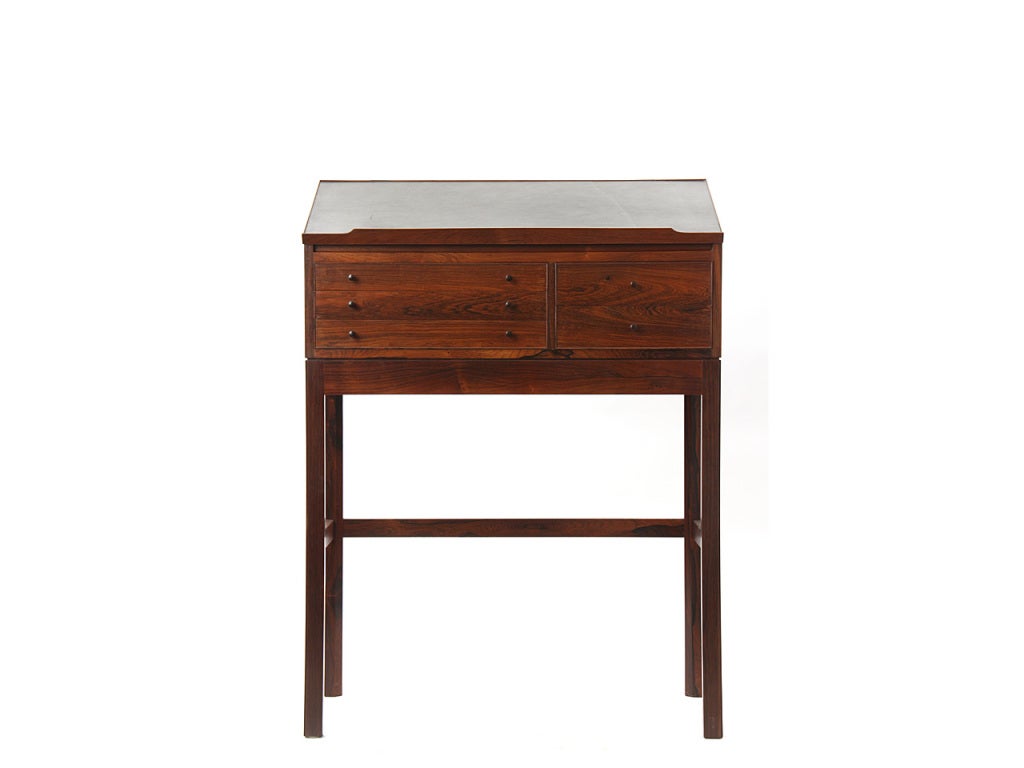 rosewood desk with black leather blotter and flip top. Five (5) drawers.