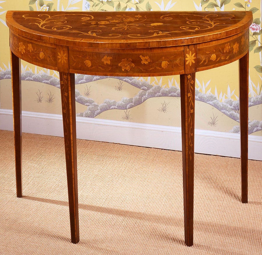 Very fine pair of harewood and marquetry demi-lune console tables, the tops having a central floral spray and serpentine foliate scrolls, with chequered inlay and rosewood cross banding and line inlay, above a matching apron, the legs inlaid with