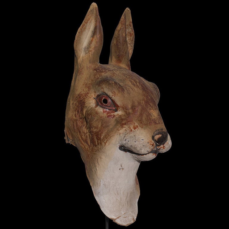 Paper mache mask of a giant rabbit on black metal stand