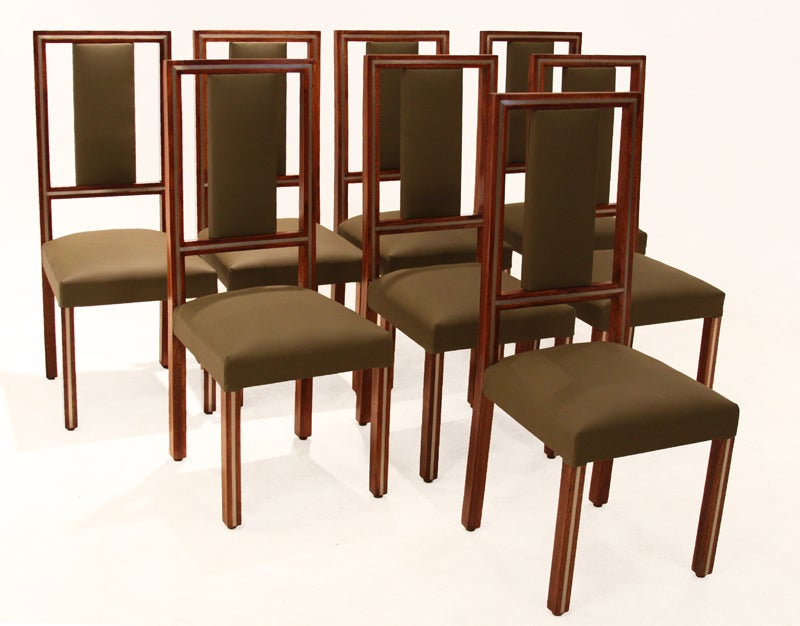 Set of eight Brazilian Imbuia wood dining chairs with beautiful olive green faux leather. The front and back frames of the chairs have an inlaid metal strips, surrounded by the Brazilian Imbuia wood.

Measure: Seat depth 16