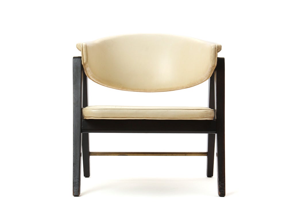 A horseshoe back armchair with white leather upholstery and ebonized mahogany frame.