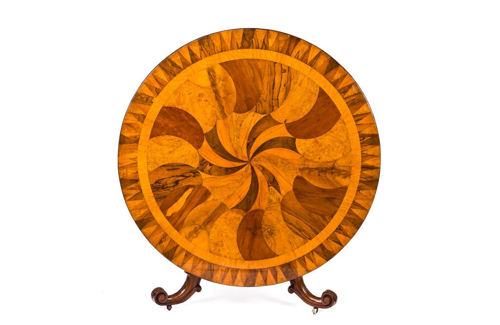Dieser atemberaubende irische Tisch aus der Mitte des 19. Jahrhunderts im Stil britischer Ceylon-Mustertische weist eine dramatische spiralförmige Intarsienplatte aus Mahagoni, Arbutus, Nussbaum, Eiche und Wurzelholz auf. Die Kippplatte ruht auf