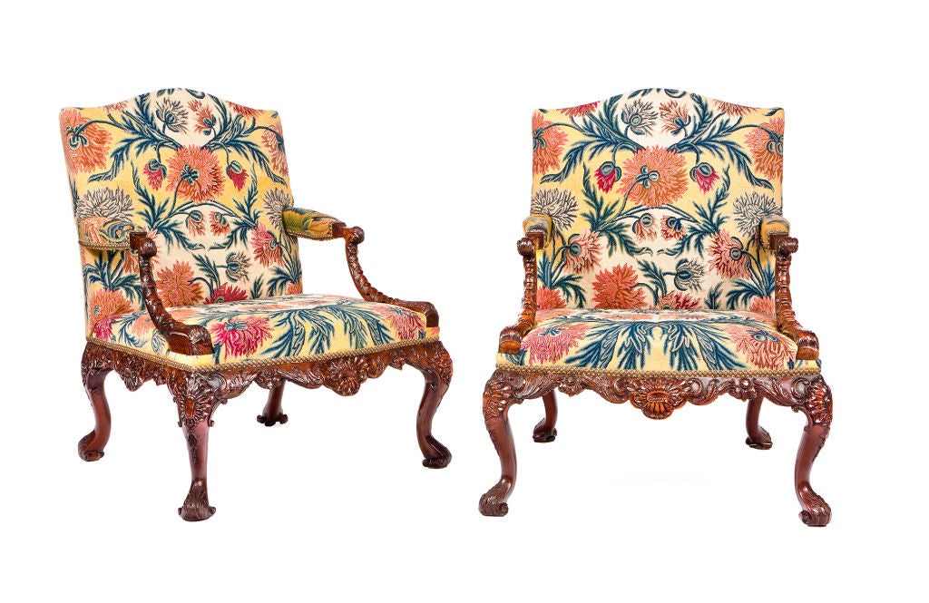 An important pair of George II walnut Gainsborough armchairs elaborately carved throughout. The hand rests of scroll form with acanthus carving, on down-curving rocaille supports ending in further acanthus. The serpentine seat rail richly carved at