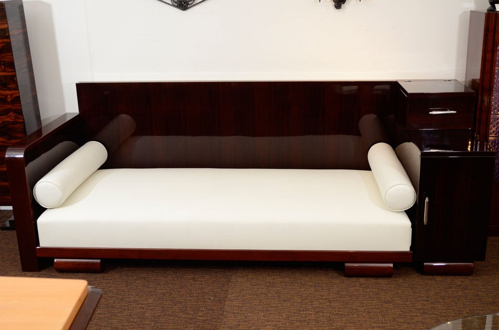 Daybed in white leather, polished chrome, rosewood and mahogany. Two cabinets on right side. Top door lifts up and bottom door opens for additional storage.