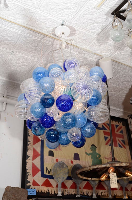 Hand blown glass bubbles in various shades of blue and clear fluted glass, with an adjustable cable and canopy.
Wired and ready to hang