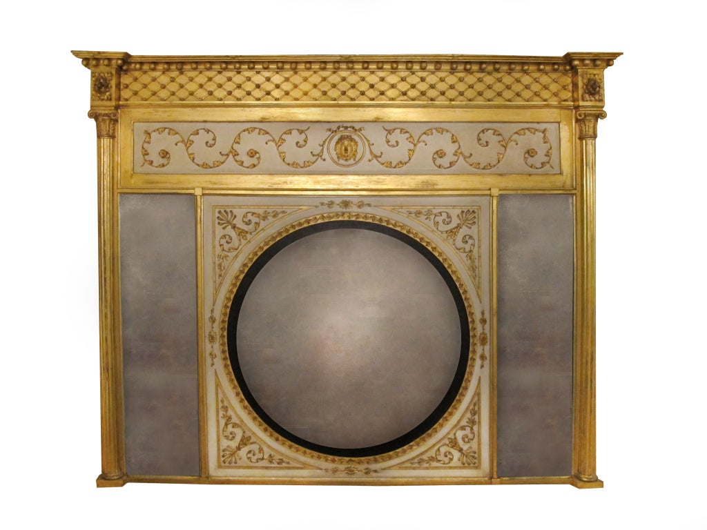 # P179 - Regency giltwood overmantel Mirror centering a circular convex plate surrounded by foliate carved and gilt spandrels, flanked on each side by rectangular mirror plates. The frieze with carved scrolling foliate details centering a mask of