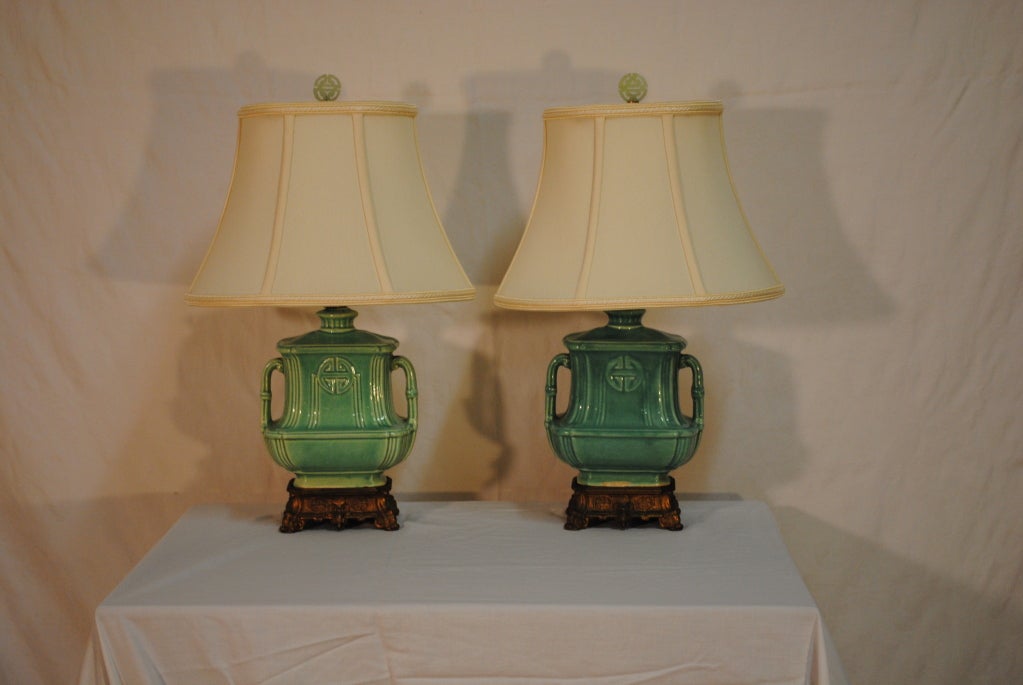 Charming pair of diminutive Turquoise Celedon glazed lamps,each adorned with the incribed Chinese Symbol for longevity,mounted on glided ornate metal bases.The accent color of the season! Rewired with cord switches,posh handswewn silk