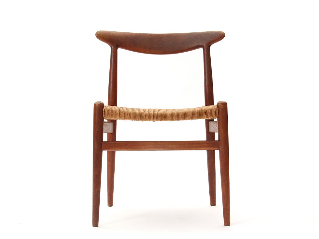 A side chair in oak with sculpted backrests and woven papercord seats.