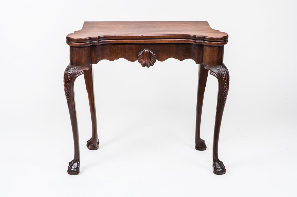 Irish Georgian mahogany card table with carved shell on frieze, cabriole legs terminating in pad feet.