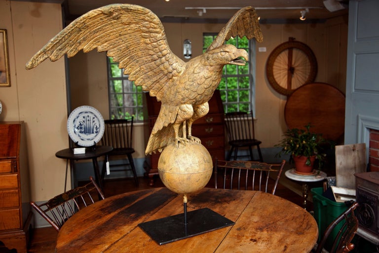 A very rare and early gilt spreadwing eagle weathervane of large size with exceptional detail perched on an oversized 10