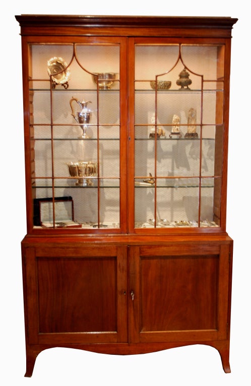 George III display cabinet. Upper section with two panned glass doors, lower section having two cupboard doors enclosing two lined shelves.